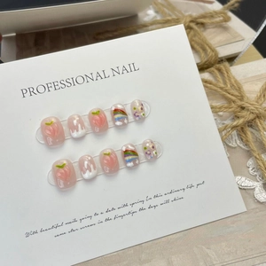 Handmade rainbow peach press-on nails with 3D fruit designs and floral art on display card