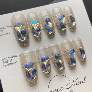 Handmade aurora press-on nails with 3D purple gems and gold glitter in ballet shape