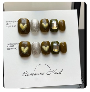 Detail of dark olive green press-on nails with 3D gold hearts and silver glitter accents