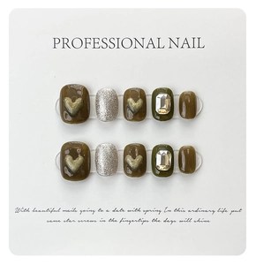 Close-up of olive green and brown handmade press-on nails with 3D hearts and rhinestones
