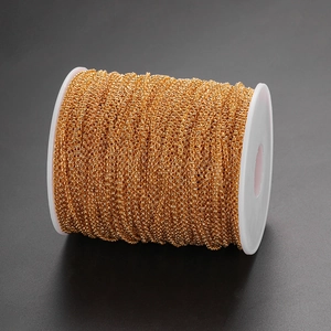 DIY jewelry making supplies with a roll of thin golden cross chain on white plastic spool