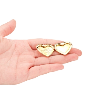 Golden heart-shaped locket necklace with I Love You engraving held in hand