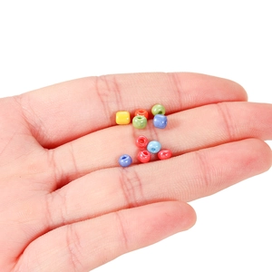 Nahaufnahme bunter 3-4mm Glasperlen in der Hand für DIY-Schmuckherstellung und Basteln