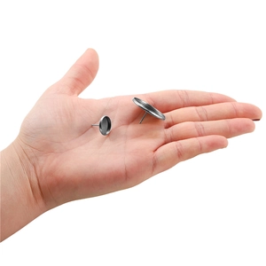 Detail of silver stainless steel earring stud bases held in hand for DIY jewelry making
