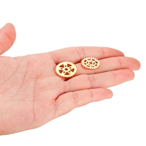 Macro-opname van twee kleine gouden steampunk tandwielen in een hand voor de schaal