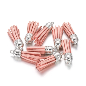 Detailed close-up of pink faux suede tassel pendants with silver caps for jewelry making