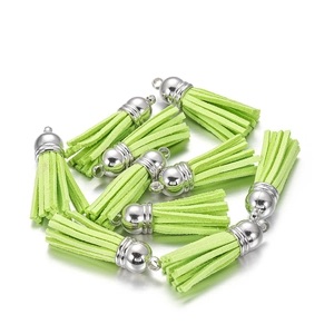 Detail of bright green suede tassel charms with silver metal caps for DIY jewelry crafts