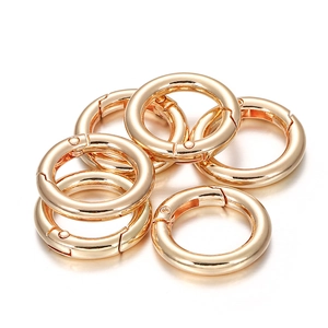 Detailed view of six polished light gold alloy spring O-rings for DIY bags and keychains