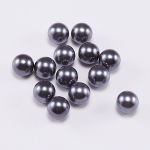 Macro shot of 13 dark grey smooth faux pearls for DIY jewelry making on white background
