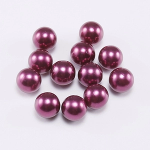 Macro detail of deep purple pearl round beads with high gloss metallic finish for DIY crafts