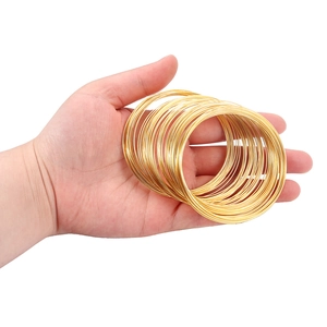 Minimalist gold plated layered thin wire bracelets shown on hand with a glossy finish