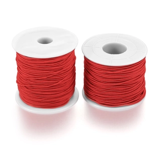 Close-up of two rolls of bright red elastic beading cord on white plastic spools