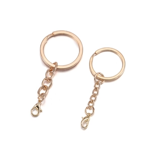 Close-up of light gold flat key rings with chains and lobster clasps for DIY jewelry making