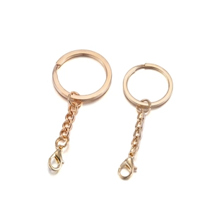 Close-up of golden metal keychains with split rings, chains and lobster clasps