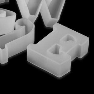 Macro shot of 3D uppercase letters E and W in translucent white silicone resin mold