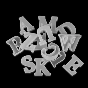 Detailed macro view of 3D alphabet silicone molds for DIY resin casting on black background