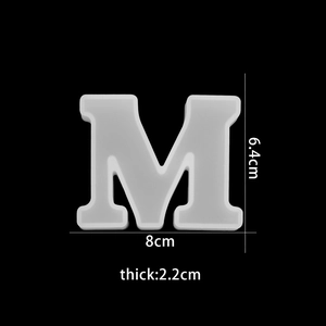 Macro view of translucent silicone mold letter M showing dimensions 8cm by 6.4cm