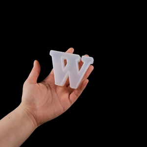 Close-up of flexible translucent silicone mold in letter W shape for DIY resin crafts