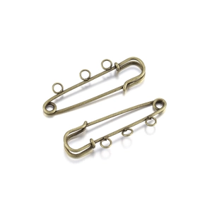 Detail of two vintage bronze alloy safety pins with 3-hole loops for DIY jewelry making