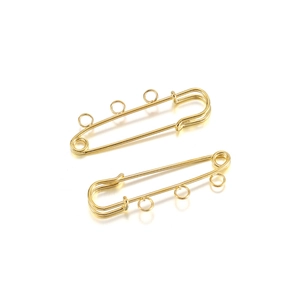Close-up of gold safety pins with three loops for DIY jewelry and brooch making