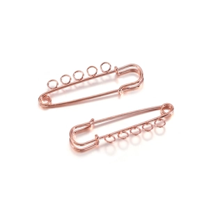 Close-up of rose gold safety pin with five loops for DIY jewelry making and charms