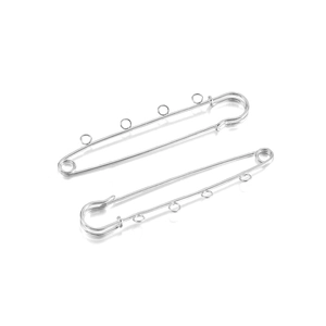 Close-up of silver metal safety pins with 3 loops for DIY jewelry and brooch making