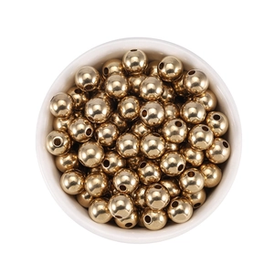Polished 18K gold brass spacer beads in a white bowl for DIY jewelry making crafts