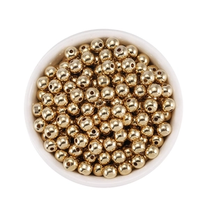 Detailed close-up of 18K gold plated brass spacer beads in a white ceramic bowl