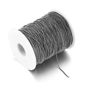 Macro view of gunmetal ball chain wound on a white spool for DIY jewelry making