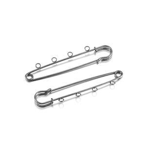 Detail of silver safety pins with four loops for DIY jewelry and tassel brooches