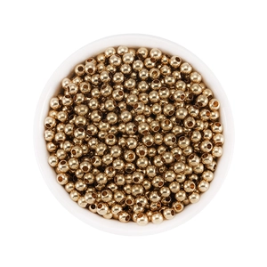 Detailed top view of 18K gold plated brass spacer beads in a white ceramic bowl