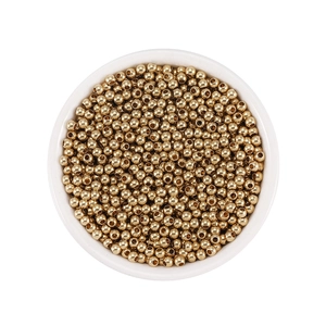Macro view of golden solid brass spacer beads in a white bowl for DIY jewelry making
