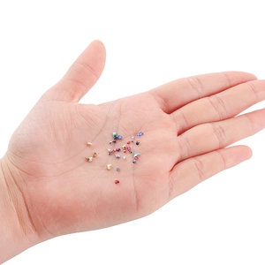 Vista macro di frammenti di vetro colorati per resina DIY e nail art sul palmo della mano
