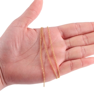 Golden round bead chain for DIY jewelry making held in hand for scale and texture