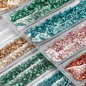 Macro view of colorful crushed glass shards in a grid storage box for DIY resin crafts