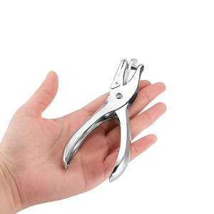 Close-up of hand holding a single hole puncher tool made of polished chrome metal