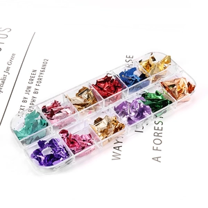 Macro view of 12-slot nail art foil flakes set in various metallic colors with storage box