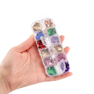 Detailed view of 12-slot storage box with multi-colored metallic nail art foil flakes