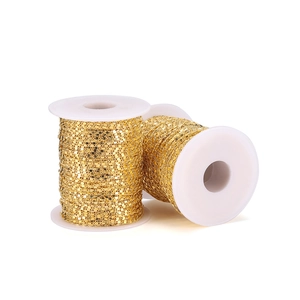 Detailed view of 1.6mm golden flattened curb chain on white spools for DIY jewelry making