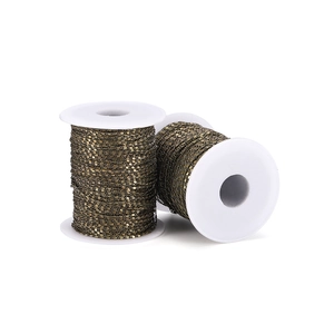 Detailed macro view of 1.6mm antique bronze curb chains wound on white plastic spools