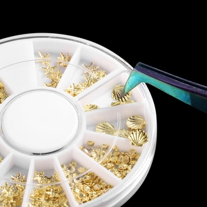 Detail of 12-grid wheel box with golden marine themed nail art metal charms and tweezers