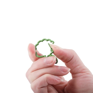 Dettaglio di un segnapunti verde a forma di pecora per lavori a maglia