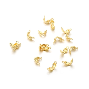 Detailed macro of golden stainless steel pea-style fold-over crimp bead covers for DIY jewelry