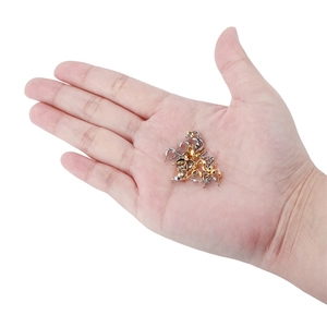 Golden and silver stainless steel bead tips for DIY jewelry making shown on a palm