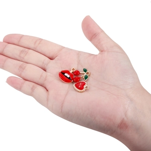Rote Emaille Lippen Herz und Kirsch Anhänger auf Goldlegierung in der Hand für DIY Schmuck