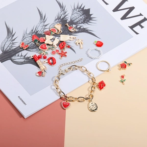 DIY-Set mit roten Emaille-Anhängern und Goldarmband mit Herz- und Lippenmotiven