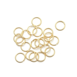 Macro view of gold-plated jump rings for jewelry making on a white background