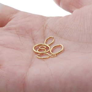 Macro shot of assorted gold-plated jump rings in palm for jewelry making size comparison