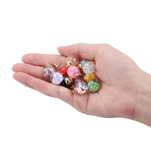 Detail of colorful sequins and glitter inside transparent glass ball pendants for DIY jewelry