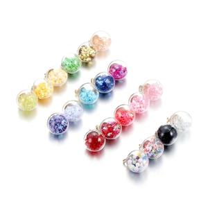 Detailed view of glass ball pendants with colorful sequins and beads for DIY jewelry